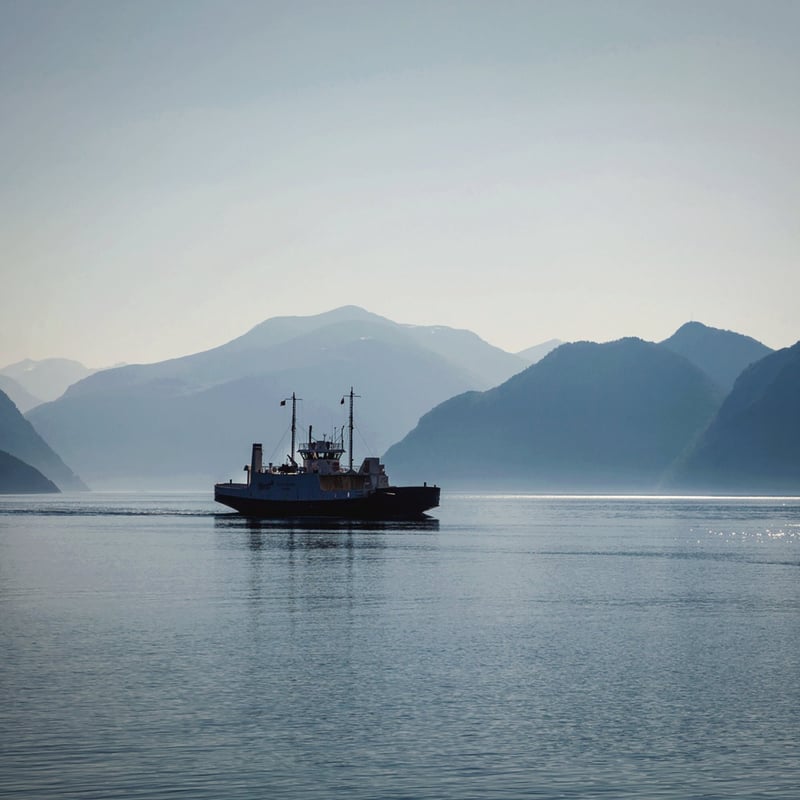 A fishing boat on a fjord under low cloud