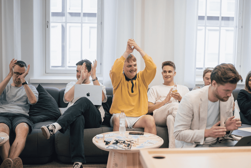 Vainu colleagues cheering together on the sofas of the Helsinki office lounge