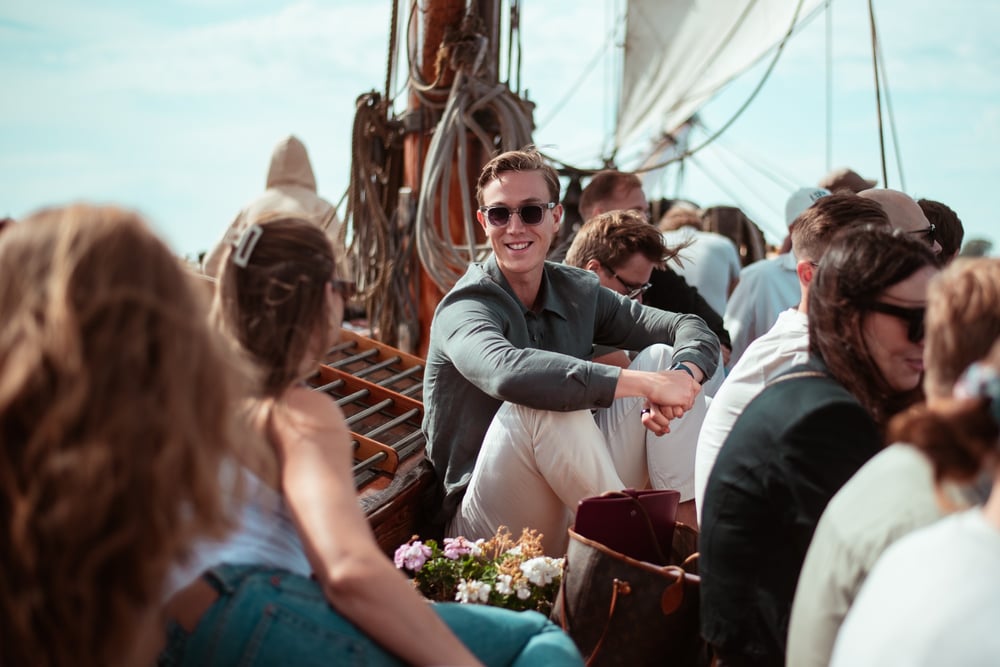 Vainu-teamet tillsammans på däck på ett segelfartyg i trä en solig sommardag