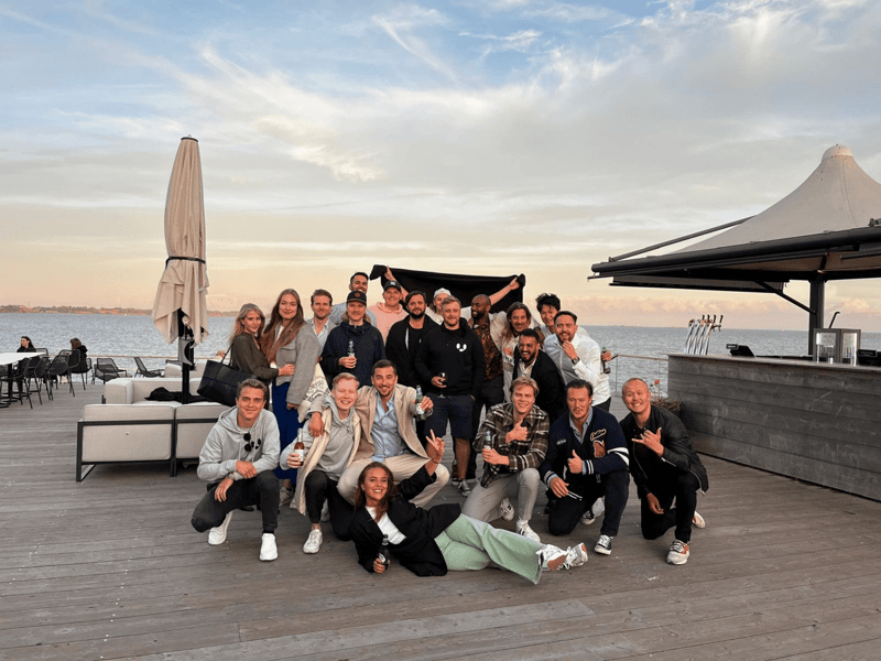 The Vainu team gathered on a waterfront deck at sunset